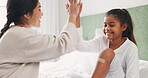 Adhesive bandage, high five and a mother with her daughter in the home bedroom for injury treatment. Support, motivation or trust with a woman and girl child on the bed for help after an accident