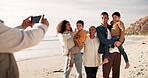 Picture, beach and happy family on holiday for a memory at sea or outdoor vacation for bonding together. Phone, photography and group photo by the ocean by grandparents, children and parents