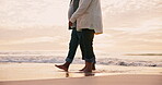 Couple, holding hands and walking on beach with legs, travel together with bonding, love and relax outdoor. People in nature, vacation with adventure and trust, marriage and support with commitment