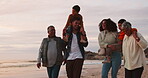 Happy, sunset and relax with big family at beach for travel, freedom and vacation. Happiness, smile and grandparents with parents and children on holiday for walking, playful and love together