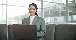 Laptop, couch and Asian woman in office lobby reading email, networking report or online research. Smile, tech and businesswoman on sofa in business lounge on computer typing on review or feedback.