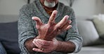 Senior man, wrist and arthritis in closeup, massage and physical therapy for injury in nursing home. Elderly person, joint pain or osteoporosis with retirement in house, rub and stretching fingers
