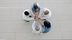 Top view, hands together and doctors with motivation, cooperation and applause in a hospital, teamwork and goals. Group, staff or medical professionals with team building, clinic mission and clapping