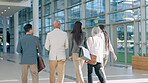 Back view, team and business people walking and talking as travel or commute to office building together in the morning. Diversity, conversation and corporate employees leave to for group meeting