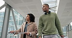 Airport, suitcase and communication with business people walking together for an international trip. Luggage, teamwork or collaboration with a man and woman employee talking in a terminal for travel