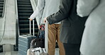Airport, travel and immigration queue by people at a terminal with luggage for international or global holiday waiting in a lobby. Closeup, hands and group in line for a flight for vacation trip