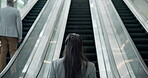 Escalator, business woman and back in office lobby for international travel to work in low angle. Walk, entrepreneur and professional on stairs at airport, convention centre or consultant conference