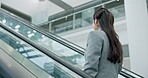 Escalator, business woman and consultant in office lobby for international travel to work in low angle. Back, entrepreneur or professional on stairs at airport, convention centre or conference flight