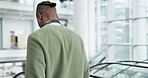 Escalator, phone and a business black man walking in an airport to travel with headphones for music. Travel, mobile and a young male employee leaving his hotel for work while reading a text message