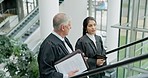 Planning, discussion and team of lawyers in collaboration on legal case or criminal investigation. Conversation, escalator and professional female attorney talking to senior judge mentor in building.