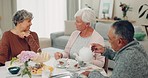Food, retirement and senior friends at a tea party together during a visit in a home for bonding. Talking, community and support with a group of elderly people in a living room for a social gathering