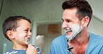 Funny, shaving and a father teaching his son about grooming or hygiene in the bathroom of their home together. Face, family and children with a boy learning how to shave with his single parent