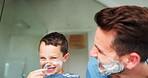 Laughing, shaving and a father teaching his son about grooming or hygiene in the bathroom of their home together. Face, family and kids with a boy learning how to shave with his playful single parent