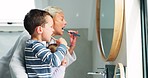 Mother, boy child and brushing teeth in mirror, bathroom or teaching for dental routine, hygiene or self care. Mom, kid and toothbrush for wellness, health or results to start morning in family home