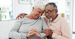 Senior couple, hug and sitting in retirement home with love, support and care in marriage. Elderly people, happy embrace and romance in a house with a smile and relax together with trust and bonding