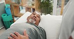 Physiotherapy, senior man and consulting therapist from bed for recovery from injury, illness or help with back pain. Physical therapy, physiotherapist and elderly male patient in assessment office