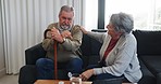 Grief, senior couple and support in a retirement home with sad man and woman together. Walking cane, depression and male person with wife helping with empathy, love and trust on a living room couch