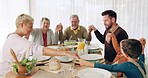 Family, praying and holding hands at lunch for worship, gratitude or blessing before eating at home. Brunch, prayer and kids with parents, grandparents and food, love and grace for meal and nutrition