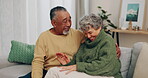 Senior couple, sofa and laughing with joke, funny memory or meme with hug, care and bonding in home living room. Old man, elderly woman and comic conversation, chat and embrace with romance in house