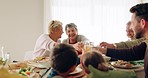 Family, lunch and juice toast in dining room with love, bonding and conversation at home. Food, cheers and children with grandparents, parents and orange fruit drink for brunch, meal or celebration