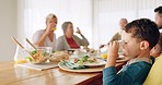 Family, lunch and boy child with orange juice at dining table while bonding, eat and sharing a meal in their home. Love, food and thirsty kid with fruit drink at brunch with parents and grandparents