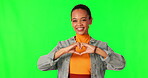 Hands, heart shape and woman portrait on green screen for support, love and charity on studio background. Happy young person with hand emoji or icon for care, motivation and kindness with a smile
