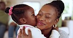 Kiss, hug and girl with mother, love and happy with fun, quality time and care with bonding in a lounge. Family, mama or female child with a smile, black parent or home with kid, embrace or happiness