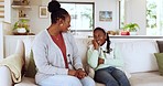 Conversation, relax and mother talking to her child on a sofa in the living room at their home. Happy, bonding and young African mom speaking to her girl teenager kid in the lounge of their house.