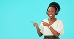 Pointing, music and black woman with headphones, happy and dance in studio isolated on a blue background mockup space. Radio, streaming and person hearing promotion, advertising and face portrait