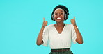 Pointing, headphones and black woman with thumbs up for music, happy and dance in studio isolated on a blue background mockup space. Radio, streaming and face portrait of person with promo success