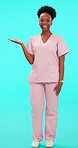 Smile, palm and arms crossed with a nurse black woman on blue background in studio for healthcare. Portrait, medical and recommend with a happy young medicine professional holding a product in scrubs