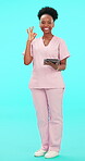 Smile, tablet and perfect with a nurse black woman on blue background in studio for healthcare. Portrait, medical and research with a happy young female medicine professional in scrubs for feedback