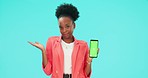 Confused, phone and black woman pointing to green screen in studio isolated on a blue background. Mobile, mockup space and person with doubt for question, shrug and tracking markers in face portrait