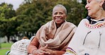 Senior women on bench in park with laughing, smile and outdoor adventure in garden for quality time. Happiness, friendship and retirement, old people bonding together in nature for freedom and fun.
