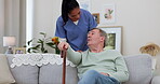 Caregiver, senior man and talking on couch in nursing home or help with healthcare for guy in retirement with walking stick. Elderly, patient or person speak to medical staff for support or care