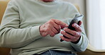 Parkinsons, phone and hands of senior man typing online to search medical condition on the internet in a retirement home. Chatting, nursing and elderly person writing on a cellphone on a sofa