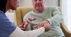 Healthcare, parkinsons and nurse with a senior man for a consultation in a nursing home. Medical emergency, checkup and closeup of a female caregiver with an elderly male person with shaking hands.