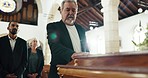 Funeral, church and man with hand on coffin for goodbye, mourning and grief in memorial service. Depression, family and sad male person with casket in chapel for greeting, loss and burial for death