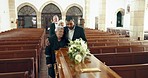 Funeral, church and people hug by coffin for goodbye, mourning and grief in memorial service. Depression, sad family and man embrace mother by casket in chapel for greeting, loss and burial for death