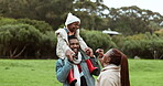 Father, mother or child in park as a black family in nature outdoors in countryside on holiday together. Happy, piggyback or African dad bonding or enjoying vacation to relax with child, mom or smile