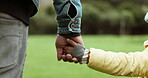 Parent, father or child holding hands in park in countryside nature together for support or care. Family, closeup or dad with kid bonding or walking on holiday vacation with love, unity or trust 