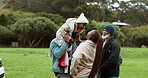 Father, kiss or child in park with mother or grandfather in nature outdoors in countryside together. Black family, piggyback or dad bonding on holiday vacation to relax with kid, mom or grandpa