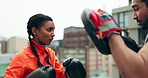 Woman, boxer and personal trainer on rooftop for training, workout or exercise together in city. Female person, fighter or sport athlete with man coach for boxing, self defense or fitness practice