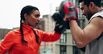 Woman, boxer and personal trainer on rooftop for workout, training or exercise together in city. Female person, fighter or sport athlete with man coach for boxing, self defense or fitness practice