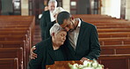 Church, funeral and senior mother and man hug for mourning death by coffin. Grief, family and son with mom by casket to console, support or interracial empathy for depressed or sad elderly woman