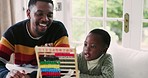 Black family, abacus and father with kid for education, learning and mathematics lesson at home. School, knowledge and happy dad teaching boy for child development, homework and educational toy