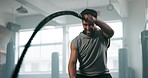 Man, rope and muscle, fitness in gym with health and bodybuilding workout, energy and action. Male athlete, sports and training equipment, power and strong with exercise, challenge and wellness