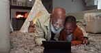 Night, tablet and grandfather with child in home for streaming, watching tv and relax together in living room. African, senior man and family bonding with technology or cartoon, movies or games 