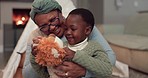 Gift, talking and a grandmother with a child and bear for love, care and bonding in a house. Playing, family and a senior African woman with a boy kid and toys as a present or for a game together