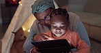 Night, tablet movies and grandmother with a child for streaming a game, cartoon or show. Happy, reading online and an African senior woman with a girl kid and tech in the dark for the web in a house